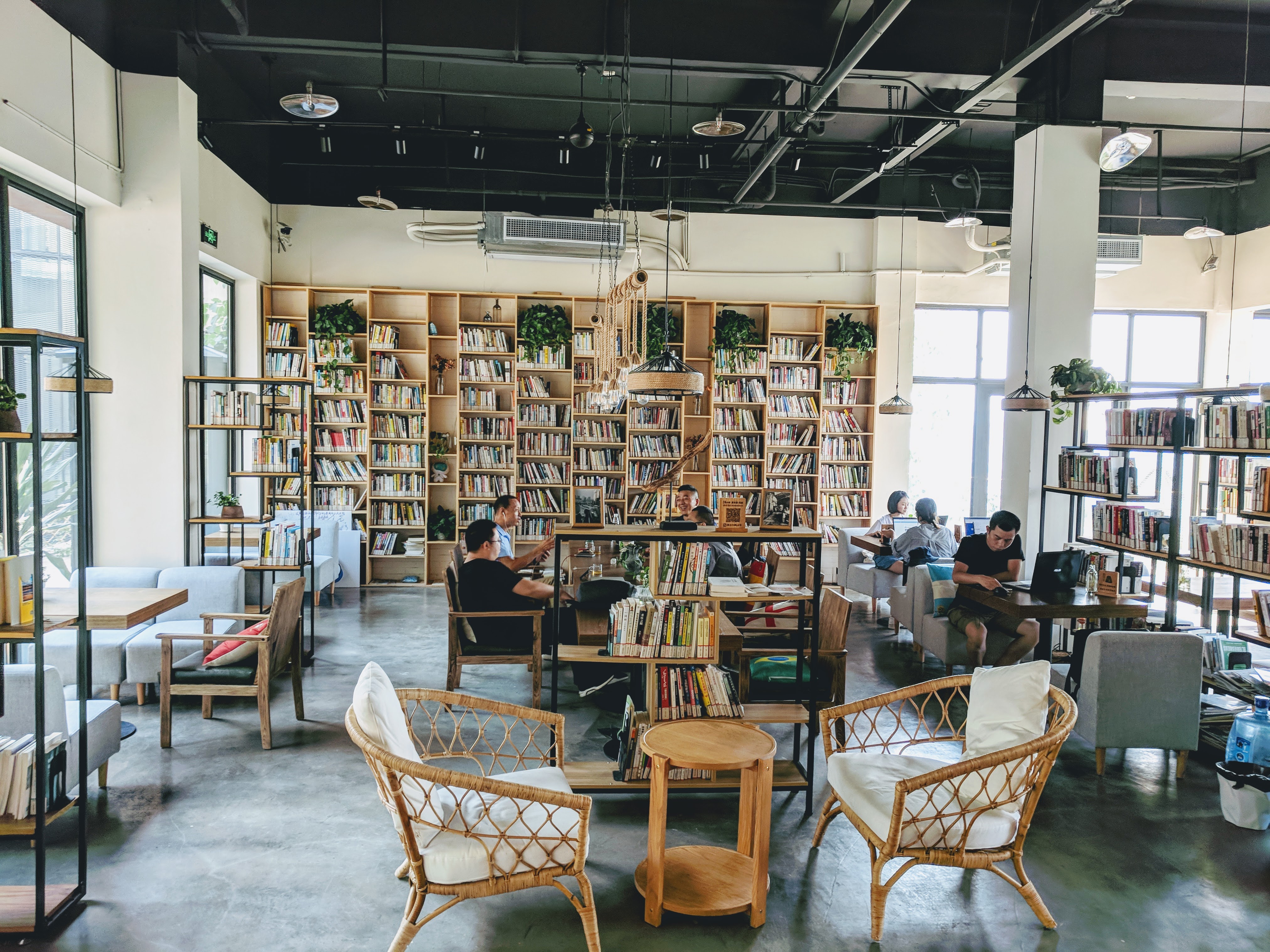 Several people quietly enjoying their day in a quaint cafe / book shop