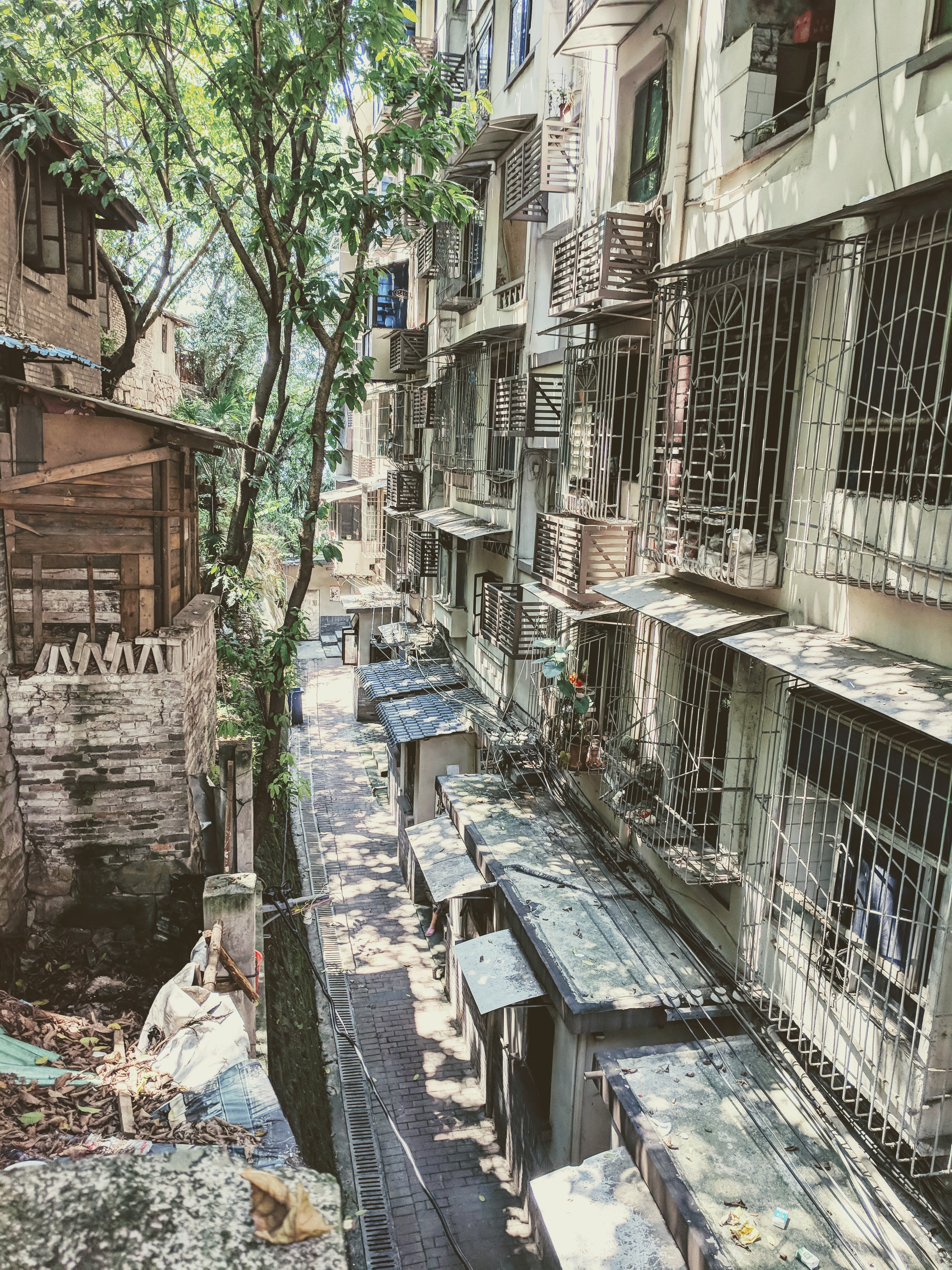 An alley filled with old buildings, the windows encased in metal bars